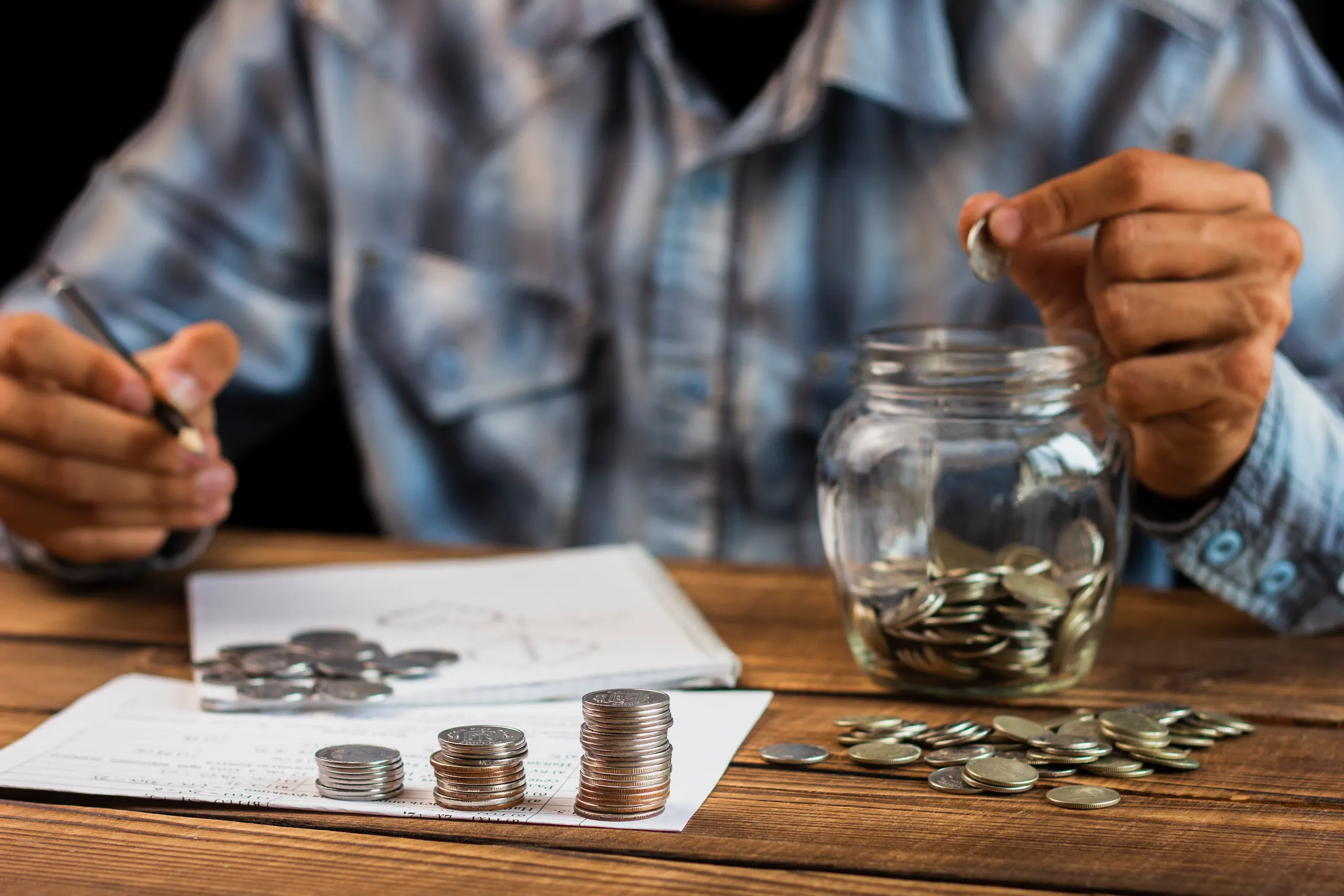 Front view of a man counting his savings, representing the financial planning needed for a No Deposit Mortgage.